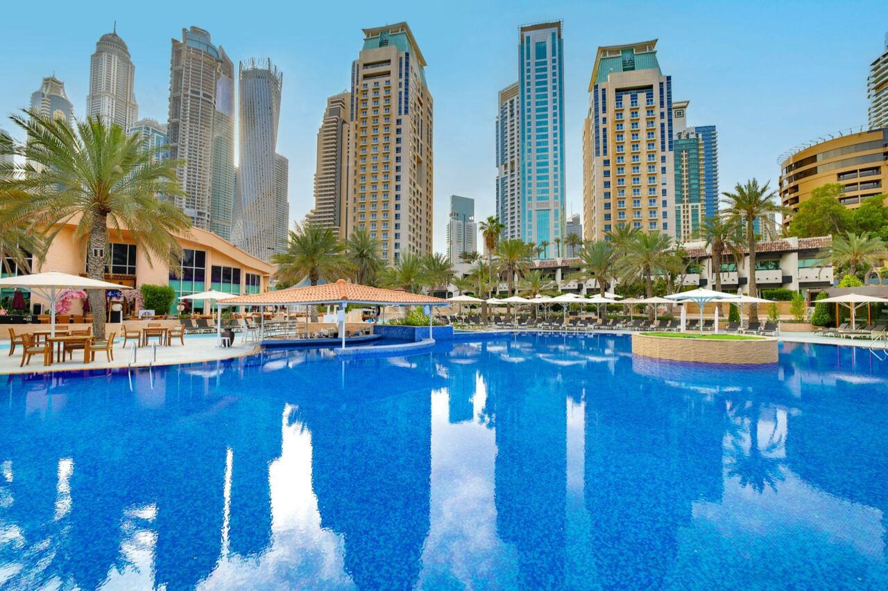 Hotelpool mit Liegen und Blick auf Stadt