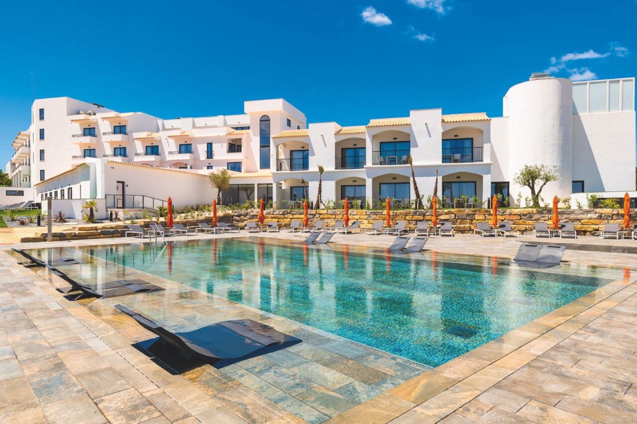 Großer rechteckiger Pool mit Liegestühlen und Sonnenschirmen