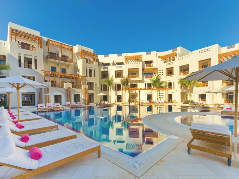 Großer Außenpool mit Liegen und Sonnenschirmen