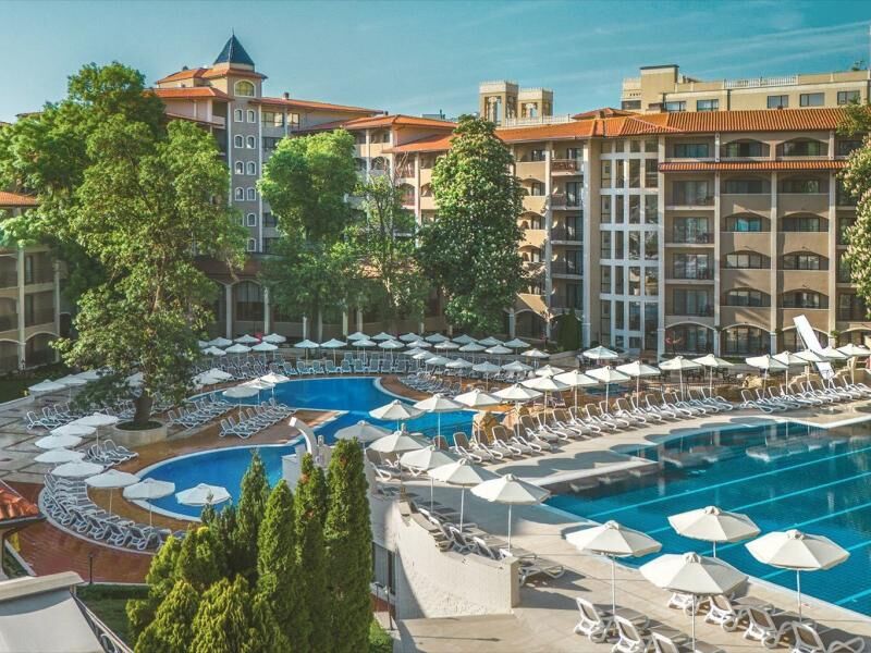 Großer Hotelpool mit vielen Liegen und Sonnenschirmen