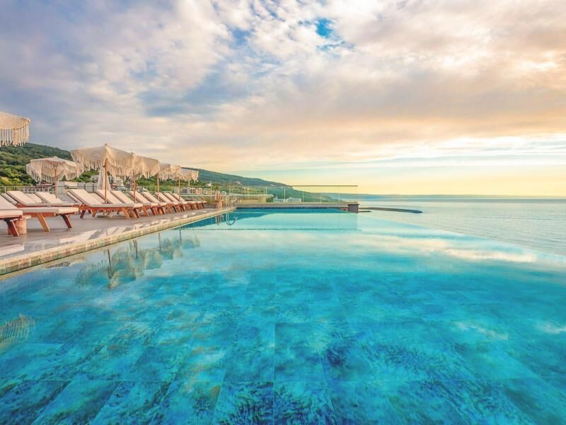 Infinity-Pool mit Liegestühlen und Sonnenschirmen