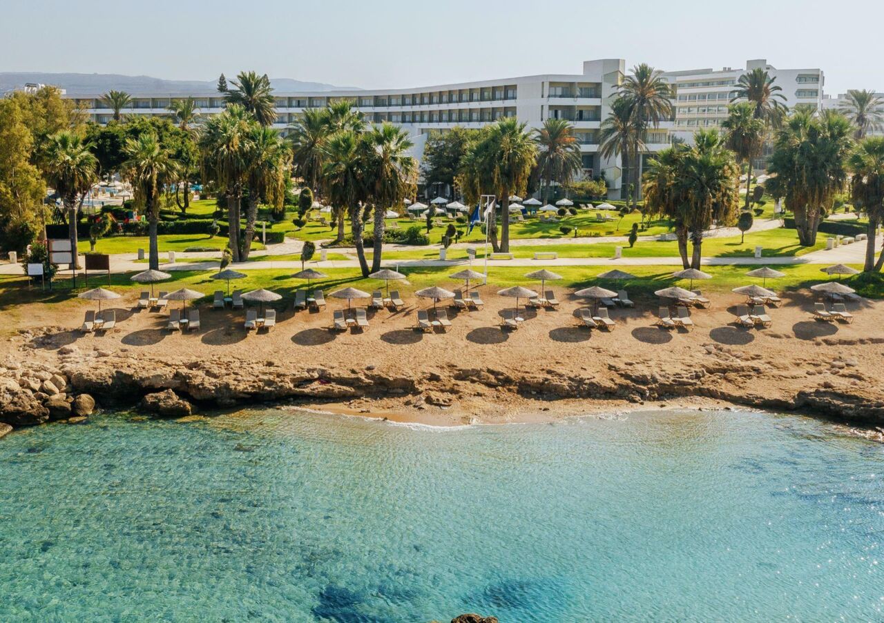 Strand mit mehreren Sonnenschirmen und Liegen