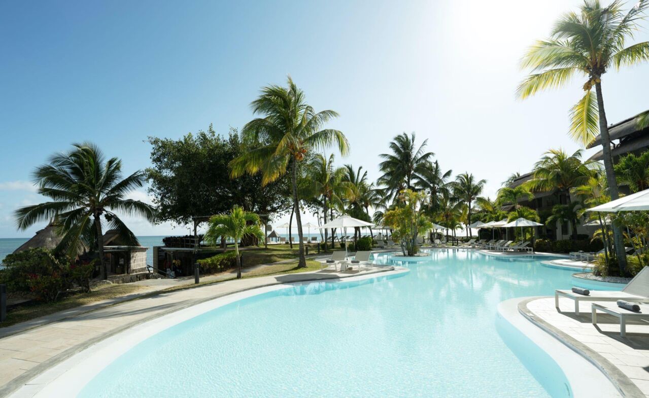 Großer Pool mit Liegestühlen und Palmen