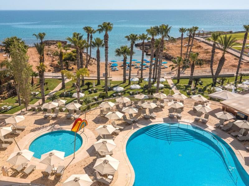 Luftaufnahme eines Hotelpools mit Sonnenschirmen und Liegestühlen