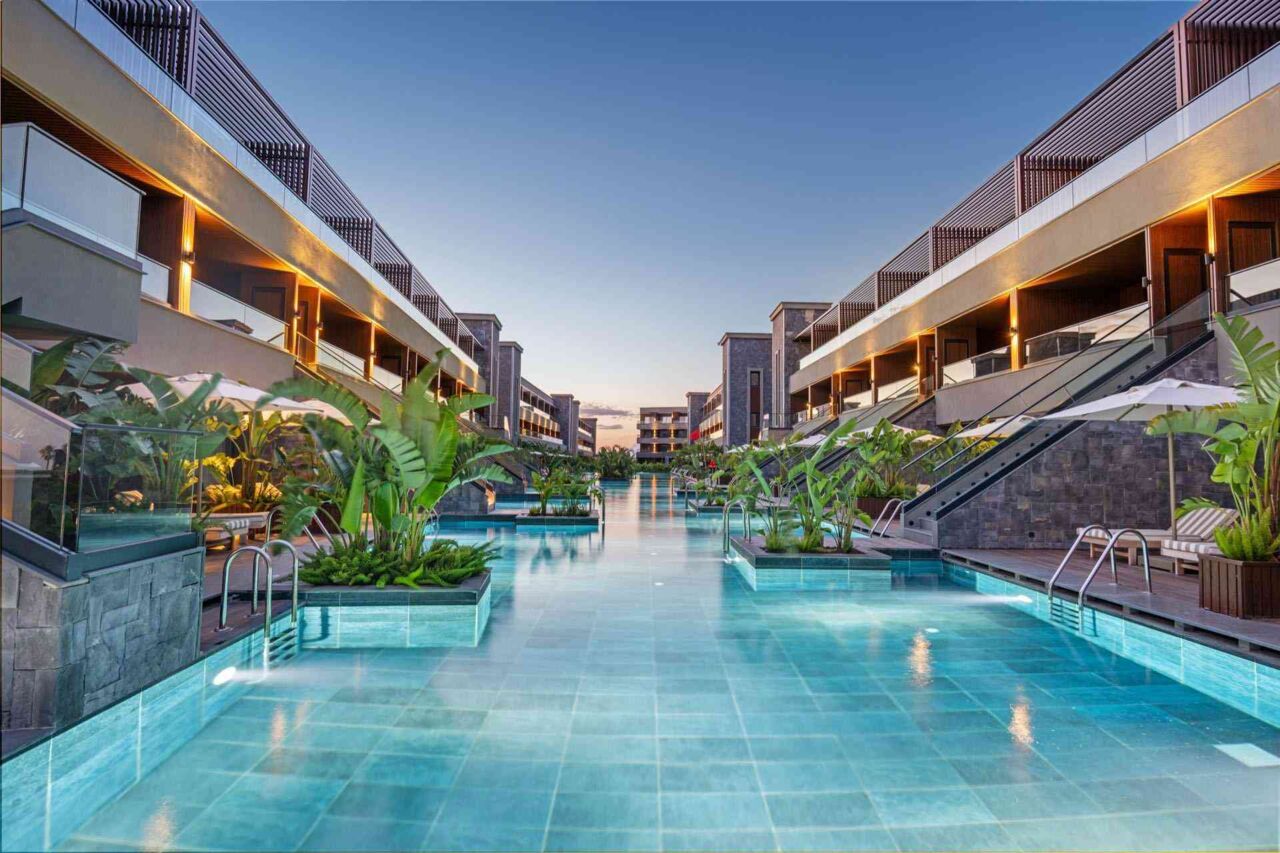 Blick auf einen langen Pool zwischen modernen Hotelgebäuden