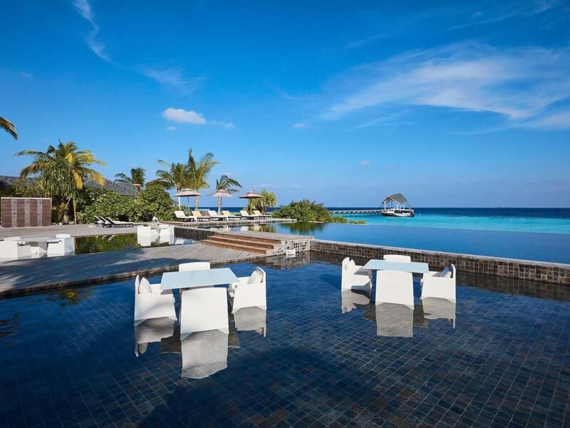 weiße Tische mit Stühlen in einem flachen Wasserbecken