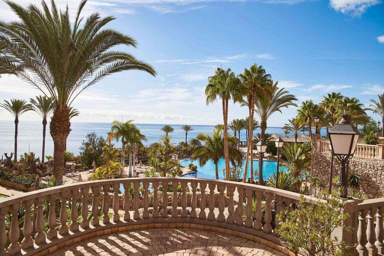 Blick von einer Terrasse mit Balustrade auf einen Poolbereich