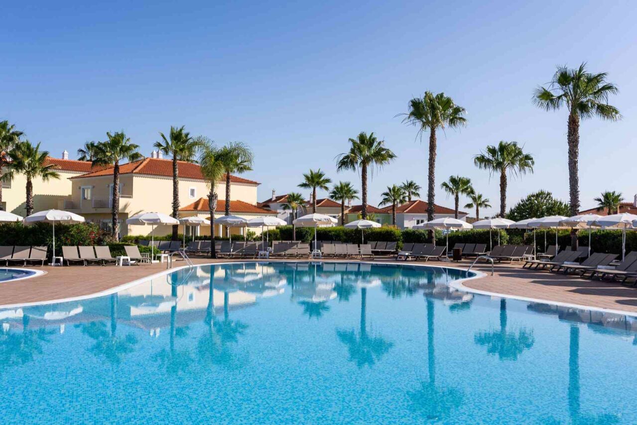 Großer Außenpool mit Liegestühlen und Sonnenschirmen
