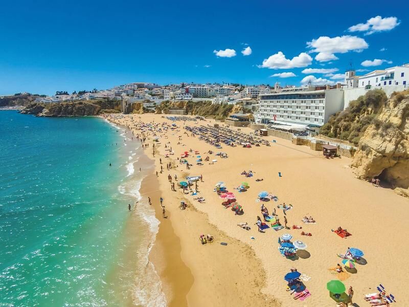 Strand mit Sand, bunten Sonnenschirmen