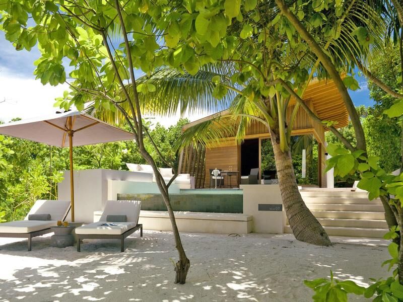 Strandbungalow mit Holzverkleidung, Terrasse mit Pool, Liegestühlen und Sonnenschirm