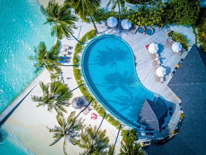 Luftaufnahme eines herzförmigen Pools an einem Strand