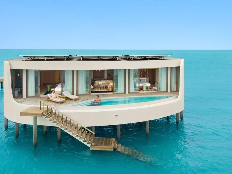 Modernes, rechteckiges Haus auf Stelzen über dem Meer mit Pool