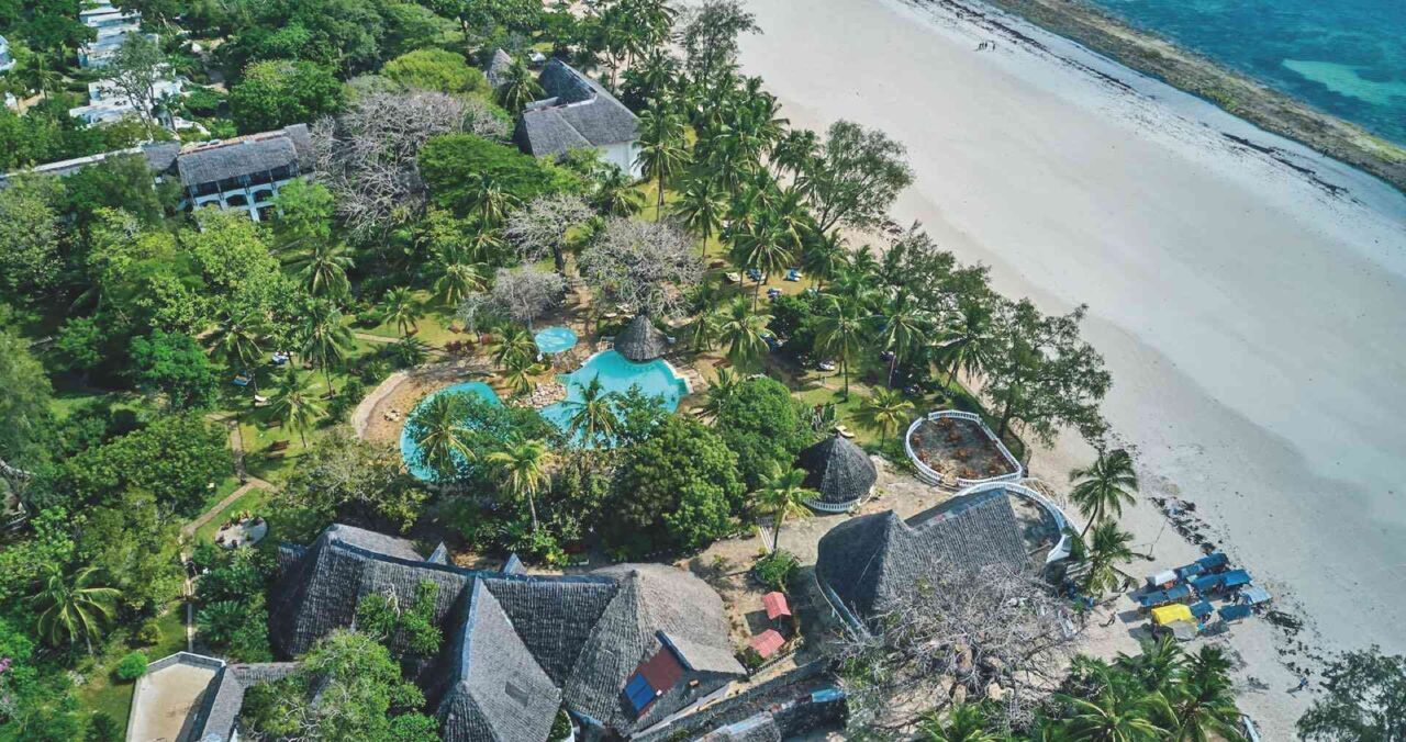 Luftaufnahme eines tropischen Resorts mit mehreren strohgedeckten Gebäuden