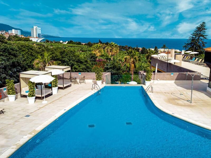 Großer blauer Pool auf einer Terrasse mit Meerblick