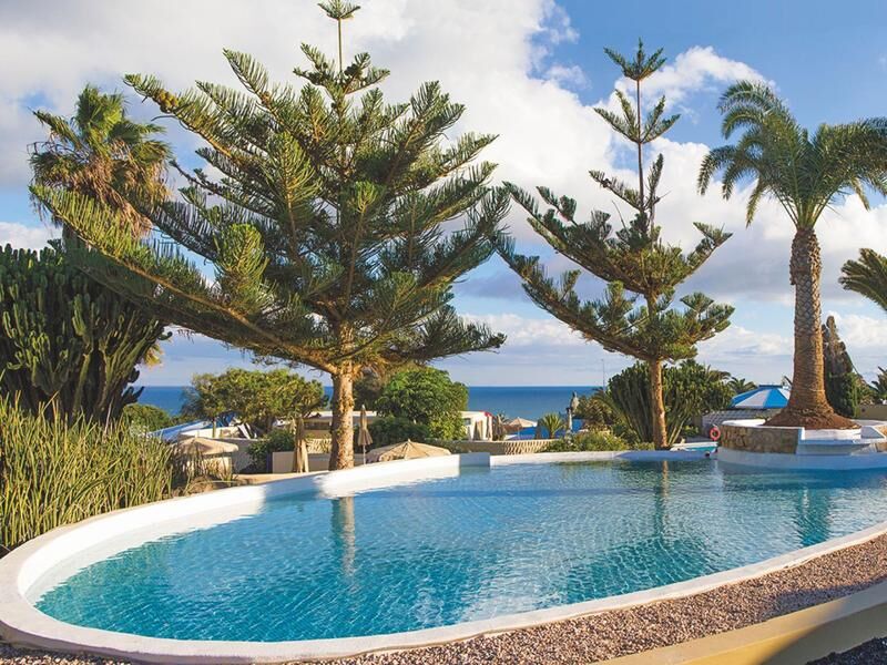 Pool mit Palmen und Meerblick
