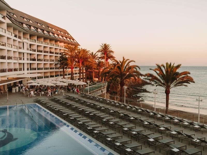Hotel mit einem Pool am Meer bei Sonnenuntergang